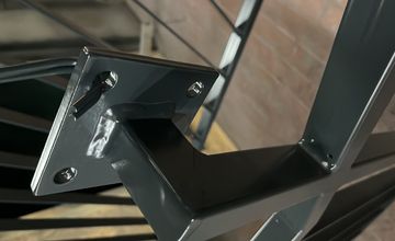 Detailaufnahme eines schwarz pulverbeschichteten Metallbauteils